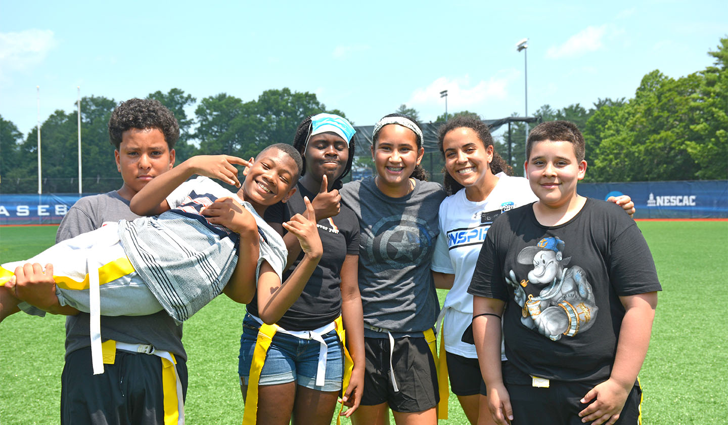 Group of students holding up one student