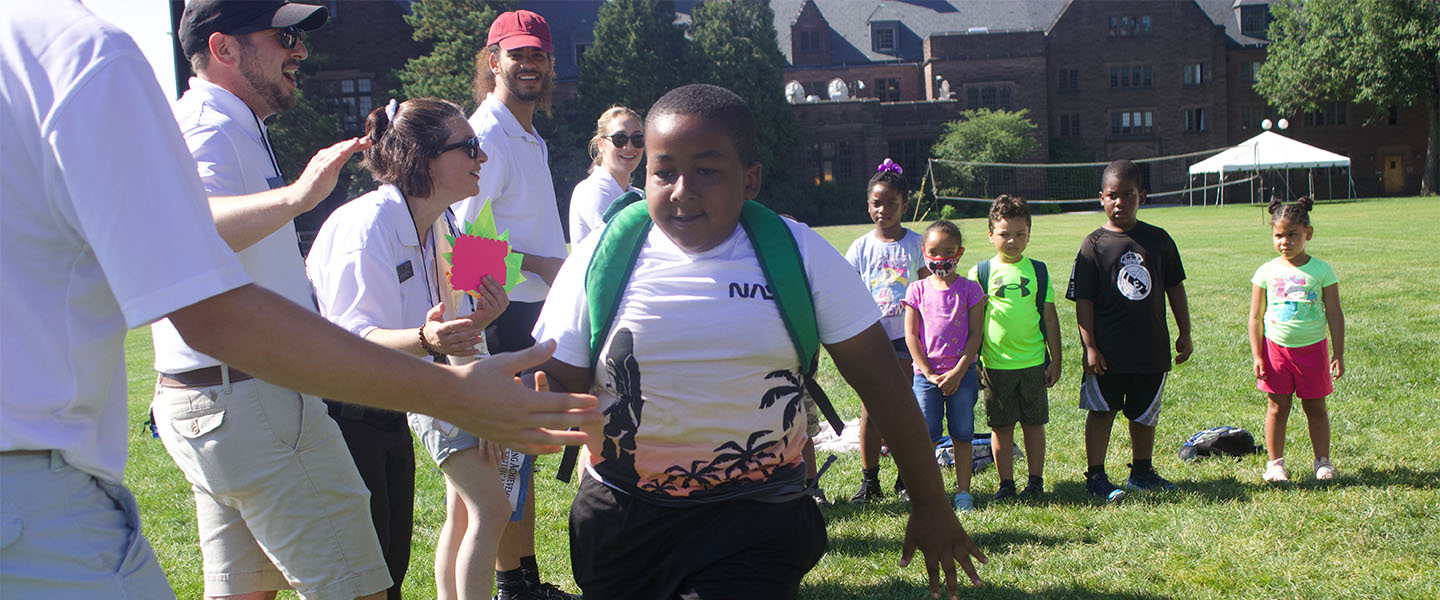 Child being greeted by camp counselors