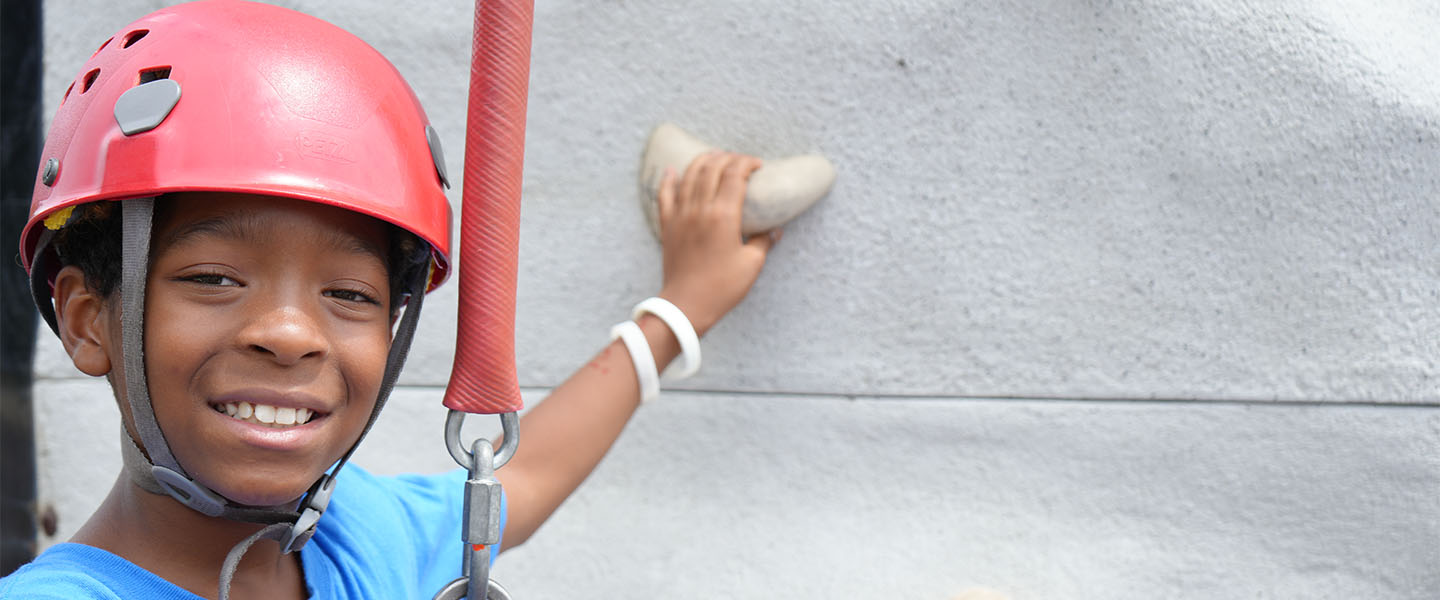Young boy on rock climbing wall