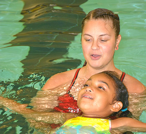 Child swimming with an instructor
