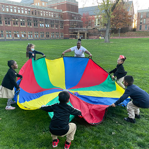 Students playing with a parachute