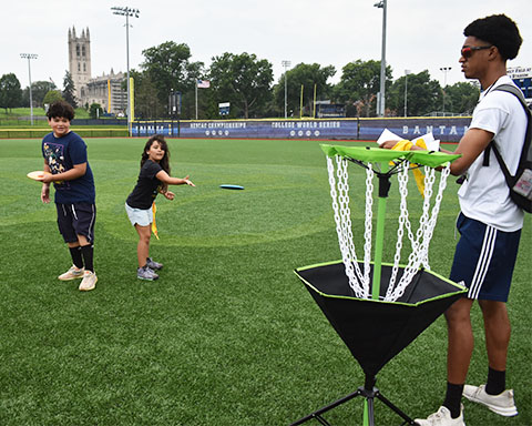 Volunteer playing frisbee golf with students